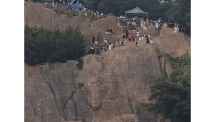 大连一跨海大桥观景台有游客翻栏杆踩空心造景石拍照，当地回应